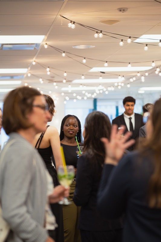 Students networking under string lights